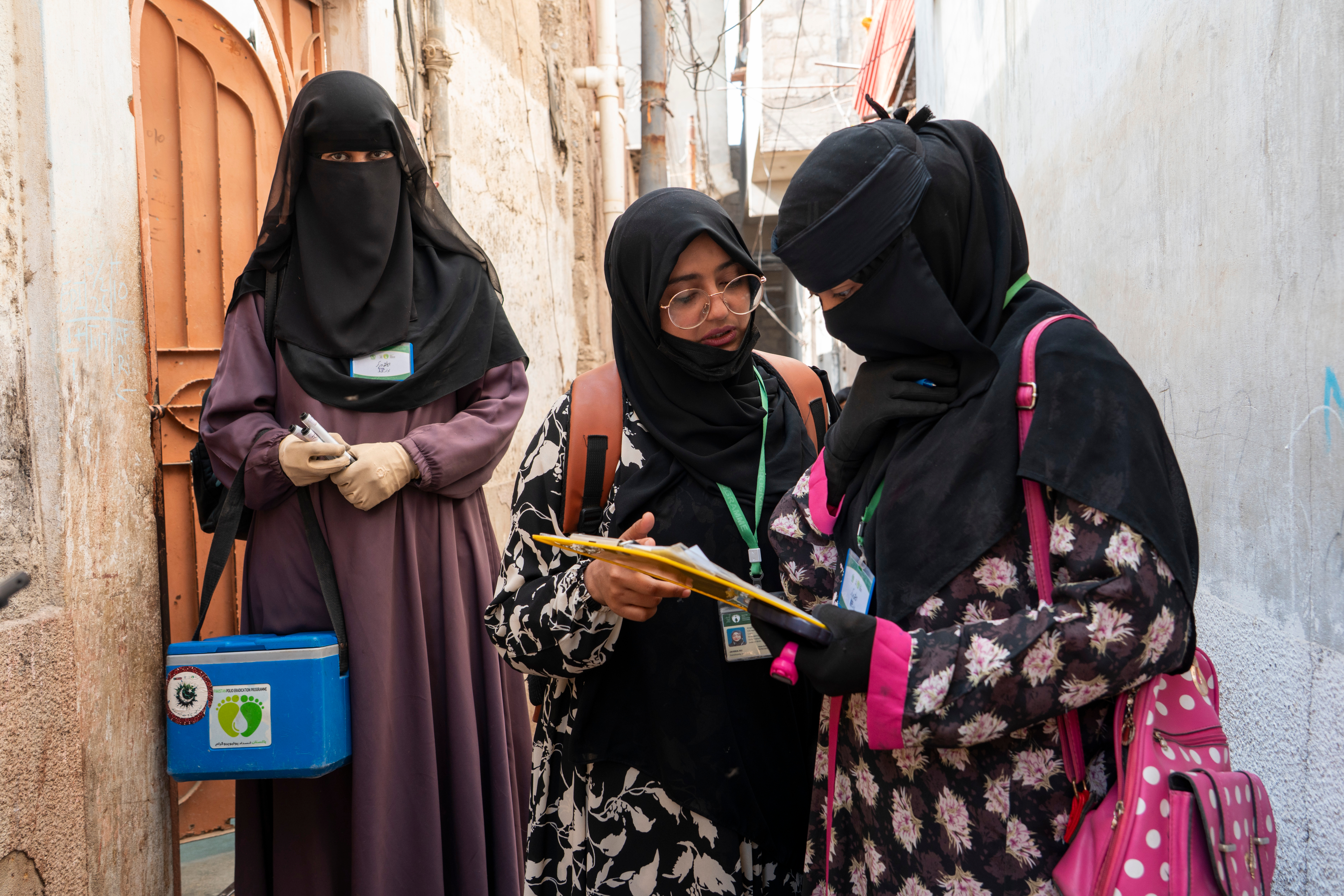 Female health workers recording details during a household visit