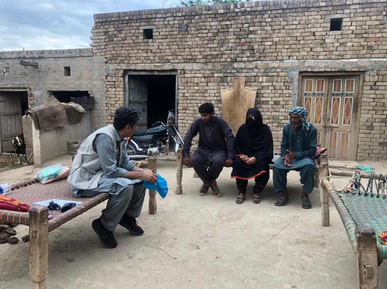 Shaheen Bibi accompanied by her son and husband is in conversation with the writer. @NEOC/2022