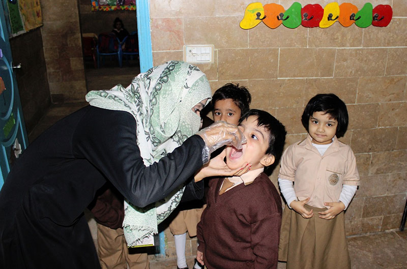 front line worker vaccinating child in pakistan.